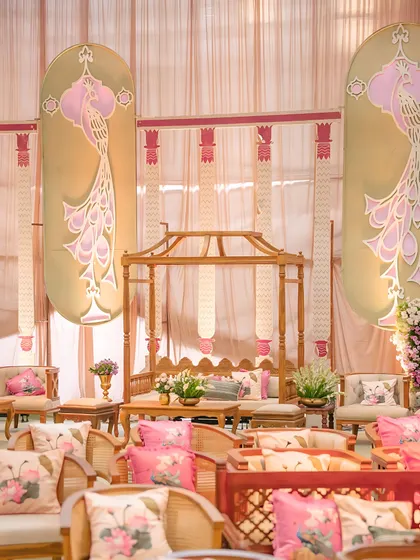 A seating area designed with custom peacock-themed panels and floral-printed cushions. Every element is thoughtfully chosen to contribute to the event's unique narrative and aesthetic.