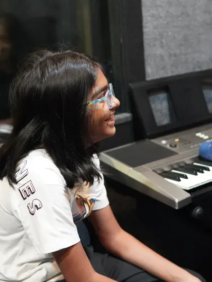 A candid shot of a student smiling during her keyboard lesson. We believe learning should be a joyful experience.