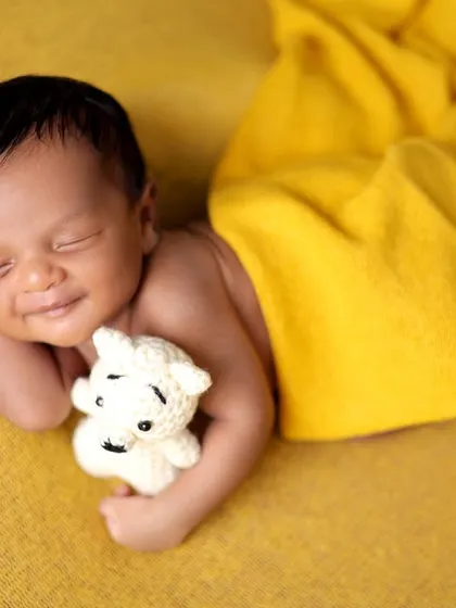 A beautiful sleeping smile from a baby in a simple yellow wrap. These are the magical moments we live to capture.