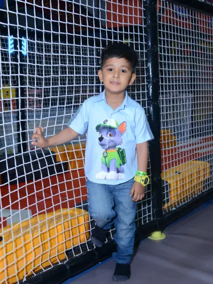 A young guest dressed as Rocky from Paw Patrol poses for a picture during a themed birthday event.