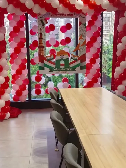 Another view of the balloon arch and branded photo booth setup for RedTape's office event. The red and white balloon theme was chosen to align with the company's branding.
