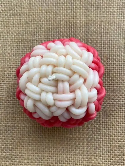 A top view of the knot-ball candle, showing the intricate woven texture.
