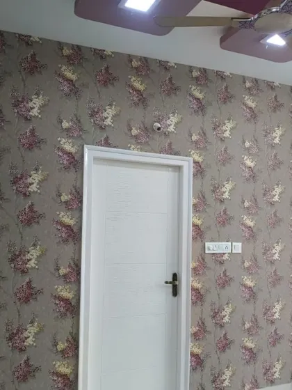 A lovely floral wallpaper in muted tones of grey and pink. This design adds a touch of vintage charm and romance to the bedroom.