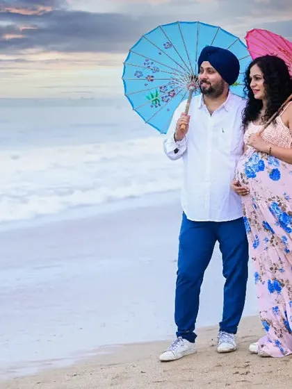 Using colorful umbrellas as props adds a touch of whimsy and color to this beach maternity shoot. It's a fun way to create unique and playful portraits.