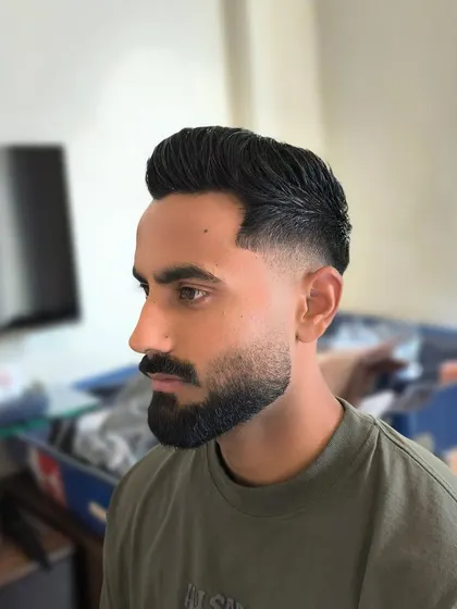 A sharp haircut with a perfectly groomed beard. The clean line-up on the cheeks and neckline is essential for making this style look polished and intentional.