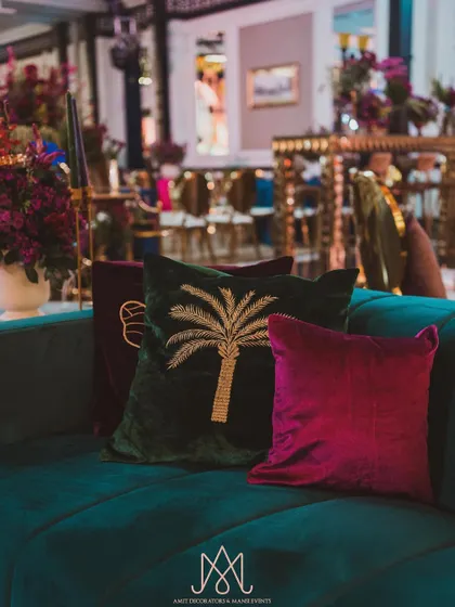 A collection of luxurious velvet cushions in jewel tones with custom embroidery, including a beautiful palm tree motif.