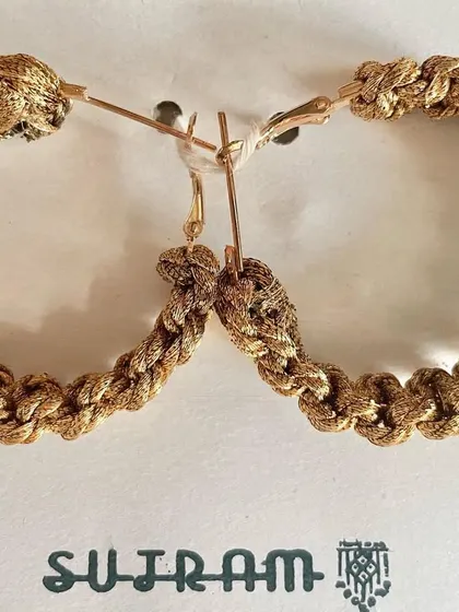 The golden macrame hoops laid flat. This design is one of my favorites to make.