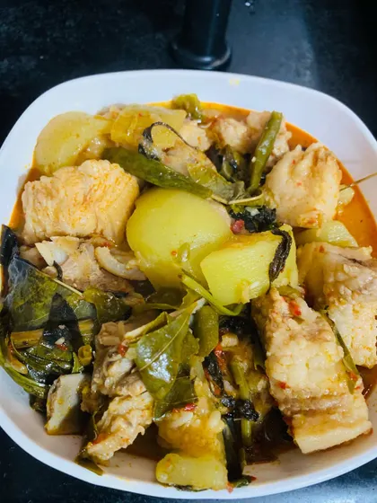 A full bowl of the fresh pork and bottle gourd curry, ready to be served. The fresh herbs add a lovely aroma to the dish.