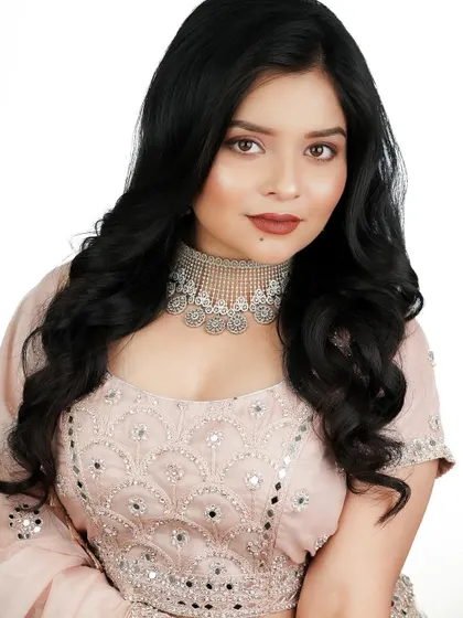 This direct portrait shows the clean skin work and the beautiful matte terracotta lip color.