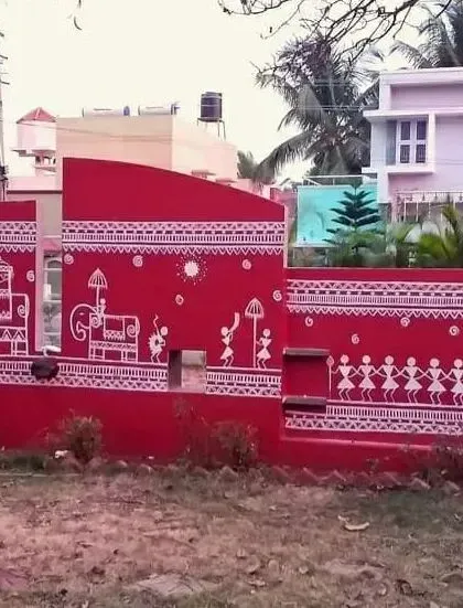 This image captures the full gate and wall section, showing how the Warli design is integrated into the architecture. The mural features elephants and dancers, creating a grand and welcoming entrance.