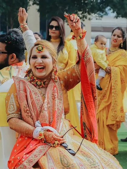 The bride's pure joy during her Haldi ceremony. Her hands are up in celebration, and her laughter is absolutely contagious. These are the moments to cherish.