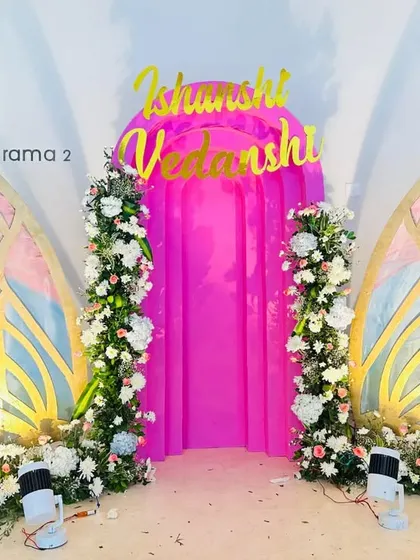 For a whimsical themed event, I created this photo backdrop with large, custom-made butterfly wings decorated with flowers. The pink fabric and personalized names complete the look.