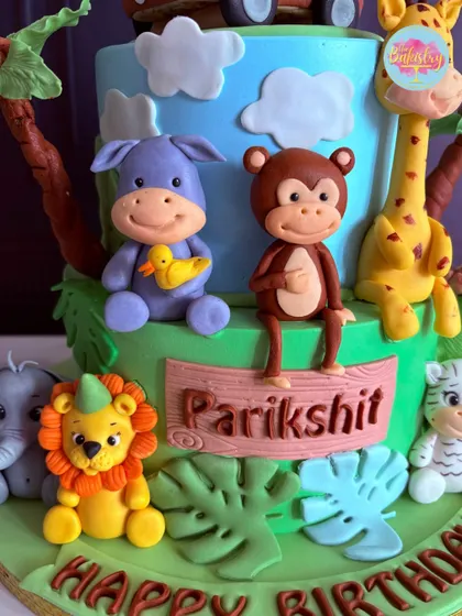 A close-up of the cheerful animal friends on Parikshit's jungle cake, including a hippo, monkey, and a lion with a party hat.