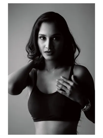A moody black and white portrait. The lighting creates deep shadows, highlighting the subject's form and creating an image full of emotion and strength.