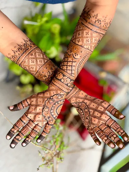 A beautiful shot of a bridal mehendi with a natural, leafy background, highlighting the organic feel of henna.
