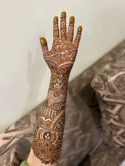 A full-arm bridal design showcasing a variety of intricate patterns. From the palm to the elbow, every inch is covered in beautiful henna.