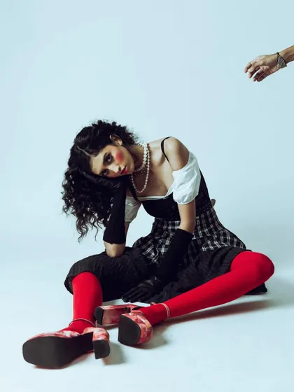A shot capturing the feeling of a puppet or doll, central to the shoot's theme. The disconnected arm adds a surreal touch.