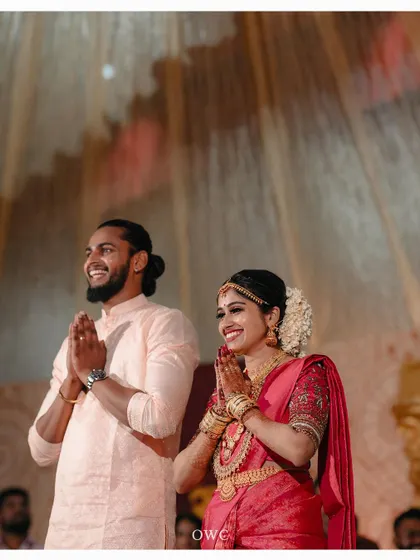 A happy couple offering a prayer or greeting guests at their wedding reception.