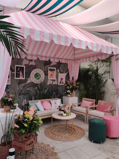 The full view of our custom-built Gray Malin inspired cabana. The pink and white striped awning and lush tropical plants created the perfect retro-chic photo corner.