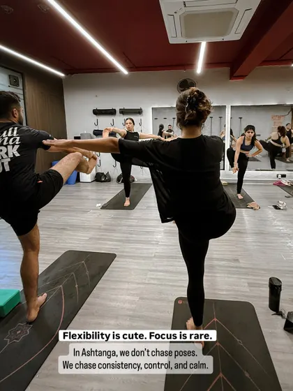 Practitioners engaged in Utthita Hasta Padangusthasana, a challenging balancing pose. This highlights our focus on control and consistency rather than just chasing flexibility.