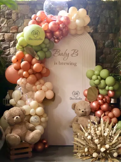 A full view of the "Baby B is Brewing" backdrop, showcasing the beautiful blend of sage, terracotta, and beige balloons.