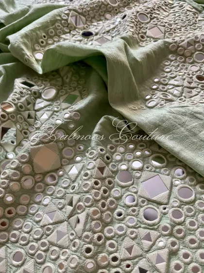 A detail shot of the palazzo's fabric, showing the dense and reflective mirrorwork.