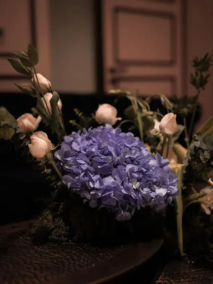 A close-up of a beautiful purple hydrangea, complemented by soft pink roses. These carefully chosen floral details, placed throughout the venue, added pops of color and elegance to the 50th birthday event styling.
