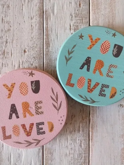 A duplicate of 85, "You are loved." These magnets feature a folksy, patterned font and botanical details, available in soft pink and blue.