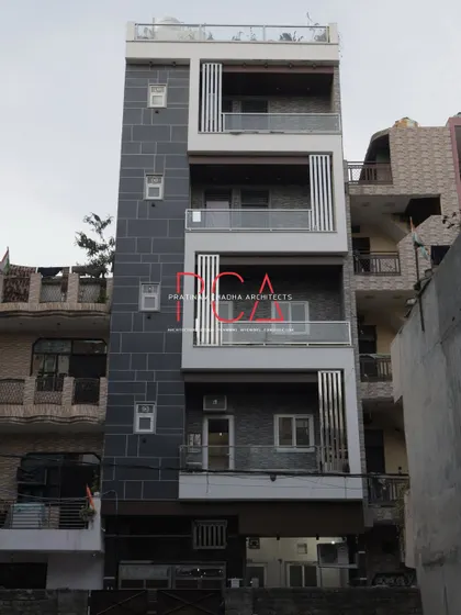A daytime shot of The Cursive Abode, showing the full height of the building and the vertical design elements that give it a sense of grandeur.