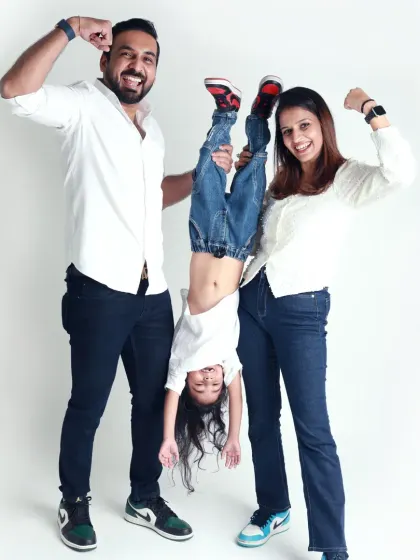 This family knows how to have fun! A playful pose with their daughter held upside down shows their energetic and joyful spirit.