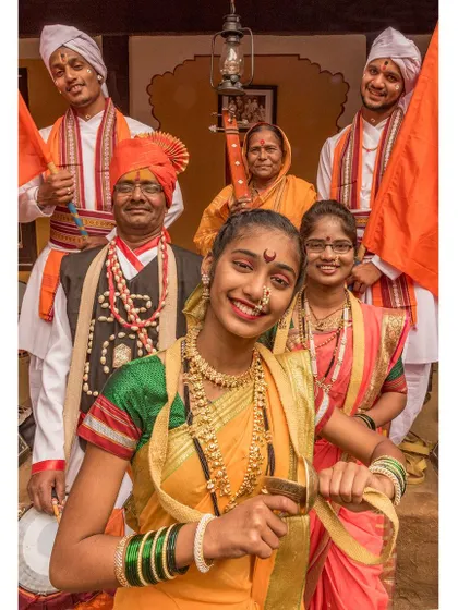 A vibrant family portrait, capturing multiple generations in traditional Maharashtrian attire. The genuine smiles and direct engagement with the camera make this a warm and lively documentary portrait.