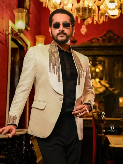 Actor Parambrata Chattopadhyay in a stylish blazer for an Anandalok magazine cover shoot. The opulent, red-walled interior adds a touch of classic luxury to this modern menswear portrait.