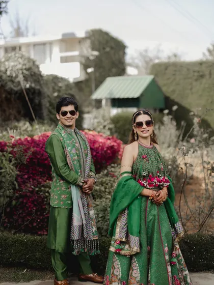A cool shot of the couple in matching green outfits and sunglasses at their vibrant Ooty Haldi.