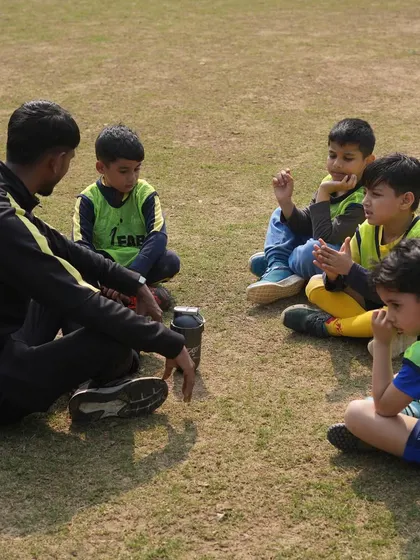A coach sitting with his players. We impart wisdom, instill discipline, and nurture the potential within each player.