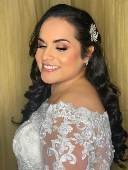 A side profile showcasing the elegant hairstyle with a crystal hairpiece. The makeup is subtle yet defining, highlighting her cheekbones with a soft, dewy glow.