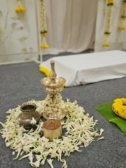 A closer look at the arrangement for the ritual, featuring brass vessels and lamps surrounded by delicate white flowers. We believe honoring these traditions beautifully is key to a meaningful celebration.