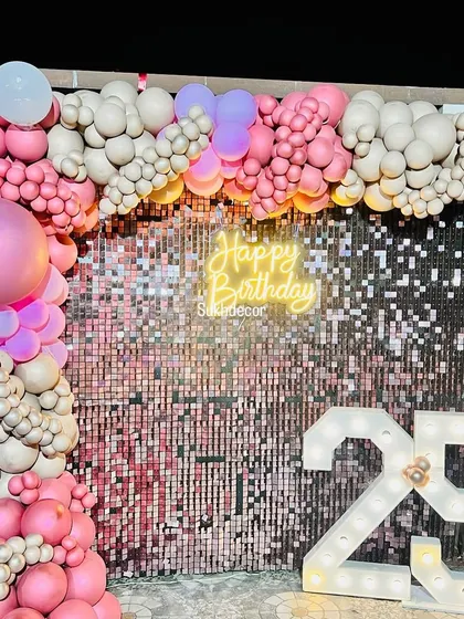 A detailed view of the balloon clusters and how they frame the shimmer wall and neon sign.