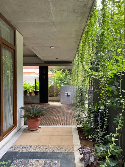 The covered verandah space provides a sheltered area to enjoy the garden, even during the monsoon. The flooring detail combines stone and traditional patterned tiles.