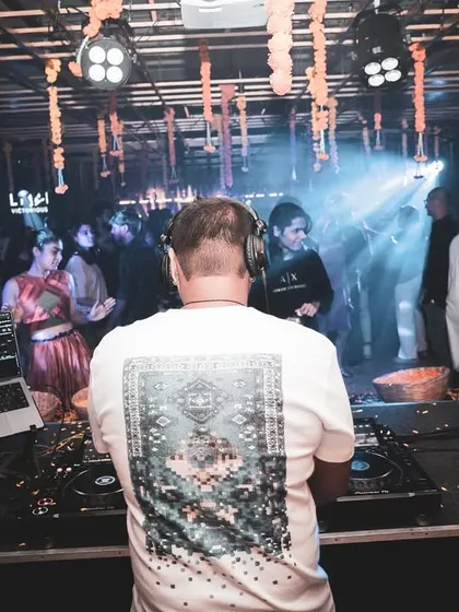 A view from behind the decks during a festive event, with traditional marigold decorations adding to the celebratory atmosphere.