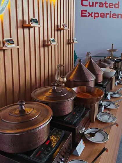 The "Gourmair" live station at the Air India launch event. We used traditional copper pots and modern induction cooktops to serve guests a curated selection of the airline's new in-flight menu.