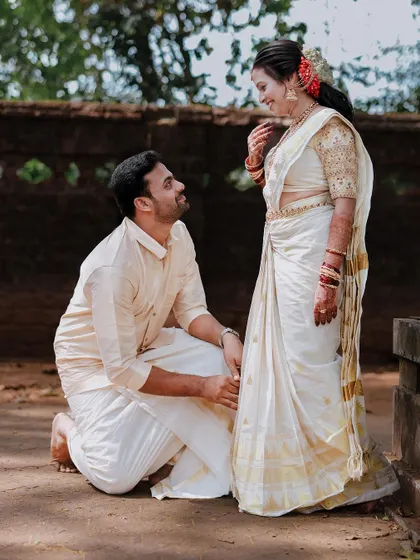 A romantic pose with the groom kneeling before his bride, a timeless gesture of adoration.