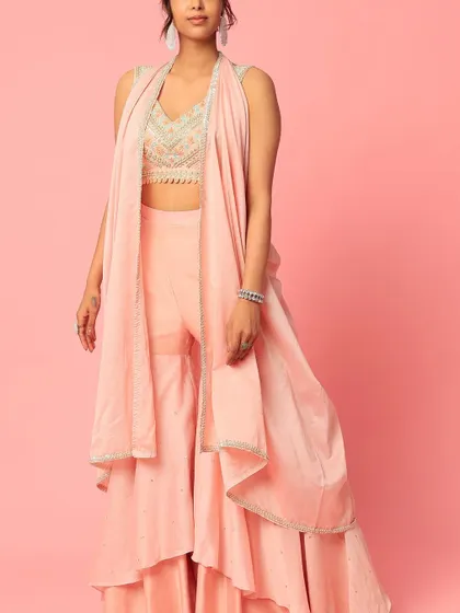 A story in every stitch. This peach sharara set with a layered design and an embroidered top is a beautiful example of custom ethnic wear.