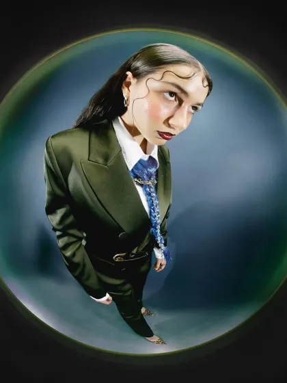 A high-angle fisheye shot looking down at the model. This perspective creates a sense of vulnerability and curiosity, drawing the viewer into her world.