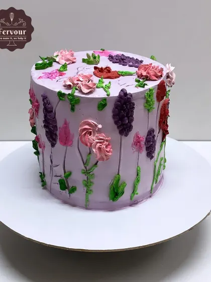 A floral cake with a "painted" look, featuring various types of flowers piped directly onto the lavender frosting. This chocolate mousse cake is a work of edible art.