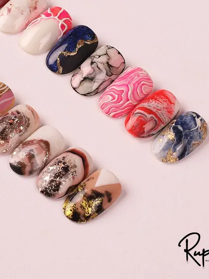 A close-up of some of the designs from my marble nail art course, showing the intricate details and color blending.