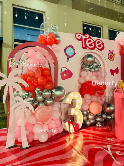 A close-up of the Barbie-themed backdrop, showing the light-up number '3' and custom name sign.