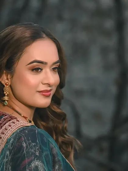 A beautiful and serene close-up portrait, highlighting her flawless makeup and elegant jewelry.