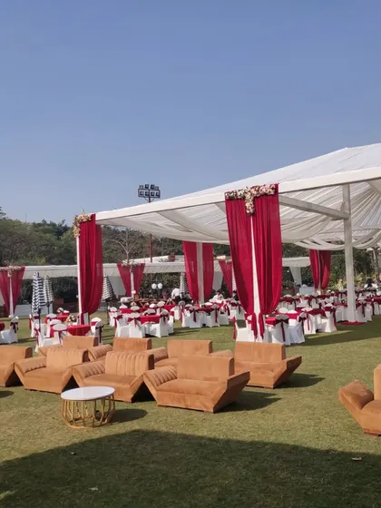 This image showcases a comfortable lounge area created on the lawn. The plush brown sofas and coffee tables offer a relaxed seating option away from the main dining area.