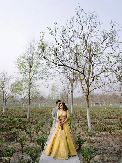 A quiet moment for the couple amidst the tea gardens of Siliguri. The sparse trees and soft light create a serene, almost poetic atmosphere for this pre-wedding portrait.