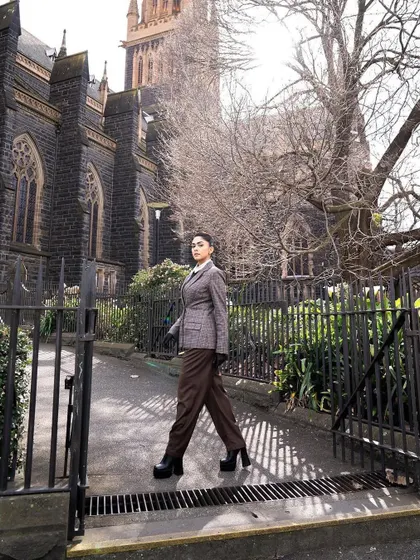 A walking shot that shows the beautiful movement of the wide-leg trousers. This is power dressing in motion.